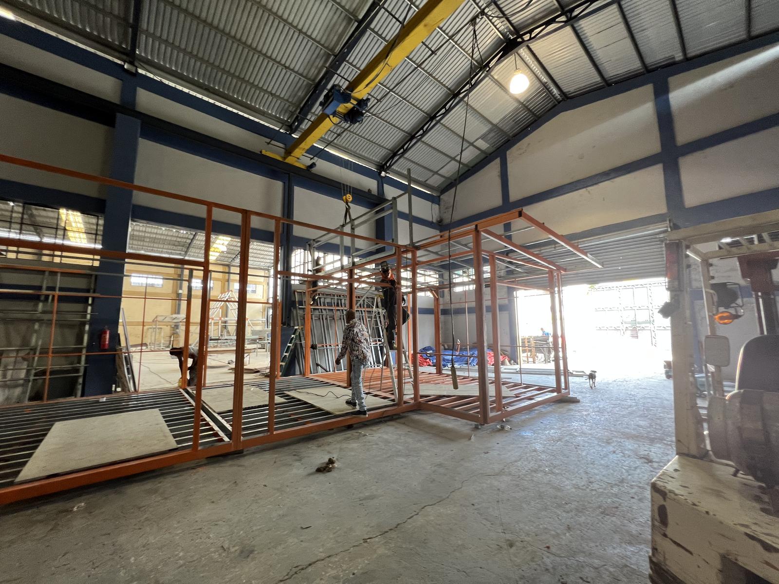 Several home frames on the plant floor under an overhead crane