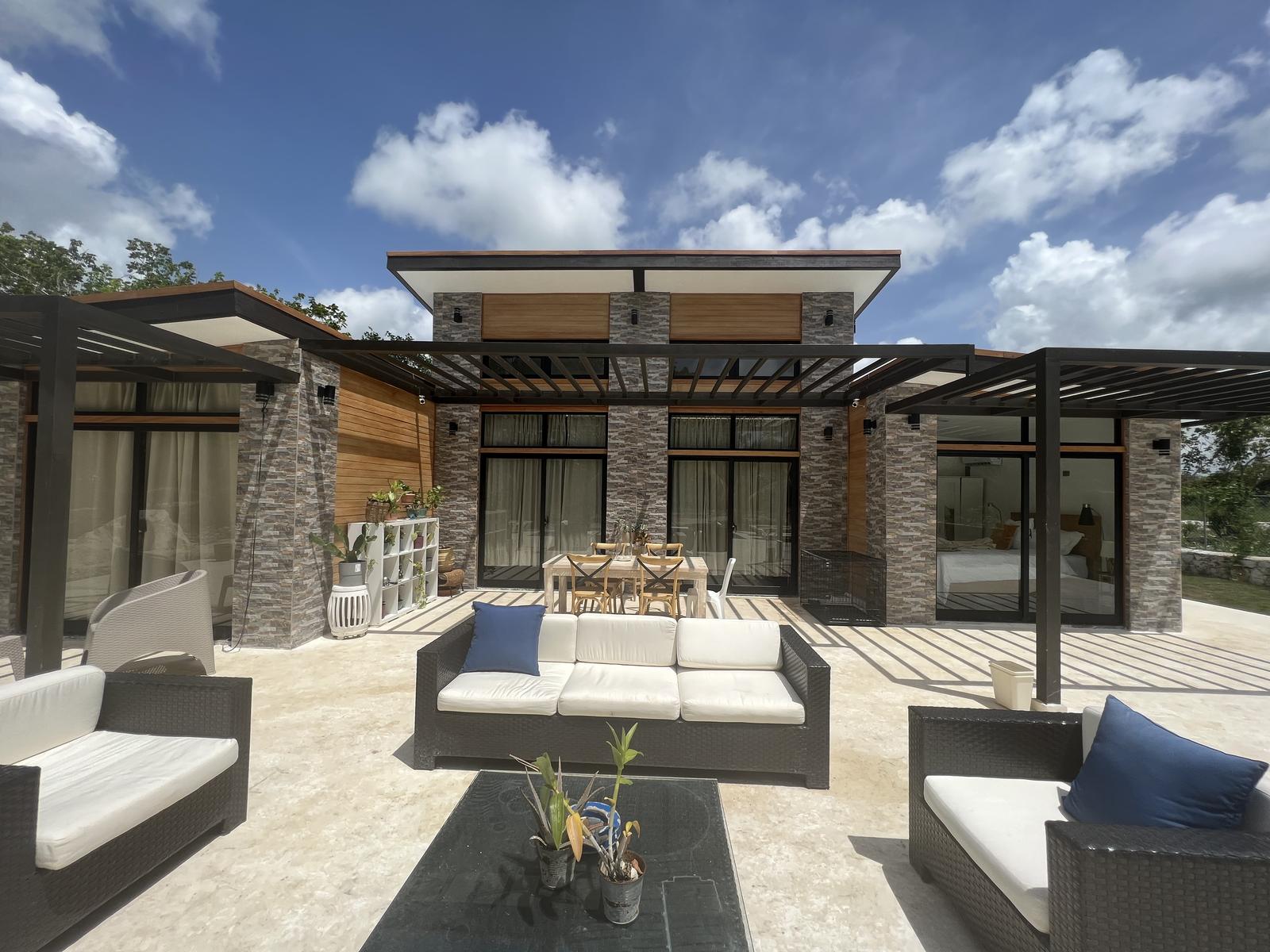 Shaded terrace with lounge furniture under a steel pergola