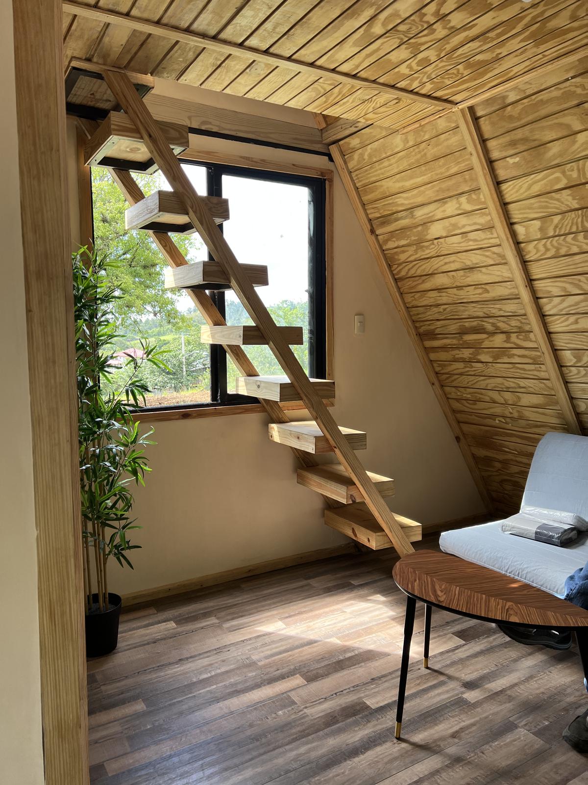 Wood-lined interior with stair and furniture